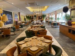 a restaurant with tables and chairs in a room at Ramee Guestline Hotel in Muscat