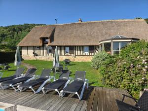 a group of lounge chairs and umbrellas on a deck at La Maraiquaise in Marais-Vernier