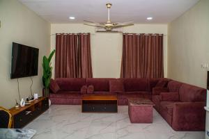a living room with a red couch and a tv at Bandari House Malindi in Zanzibar City