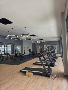 a gym with rows of treadmills and elliptical machines at Rumah Suri Homestay at Arena2 Residence Kota Warisan in Sepang