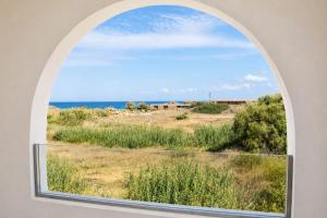 an arched window with a view of the ocean at Ela Mare Sea View Apartments in Malia