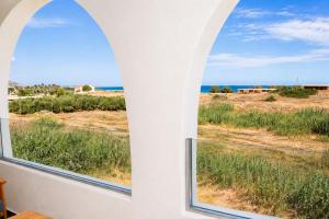 a room with two windows looking out at the ocean at Ela Mare Sea View Apartments in Malia