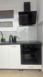 a kitchen with a black oven and a microwave at Hera's apartment in Porto Rafti