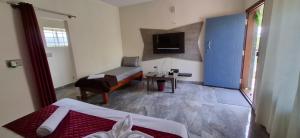 a bedroom with a bed and a desk and a television at New Peak By The Lake in Chikmagalūr