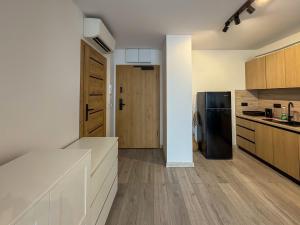 a kitchen with white counters and wooden cabinets at Apartament Bulwary 7 in Oświęcim