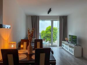 a living room with a dining room table and a television at Apartament Bulwary 7 in Oświęcim