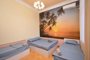two beds in a room with a painting on the wall at Tumanyan Guesthouses in Yerevan