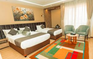 a hotel room with two beds and a table and chairs at Gautam Hotel Dhanusha in Lālbhitti +17 photos