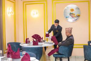 a man sitting at a table in a dining room at Gautam Hotel Dhanusha in Lālbhitti