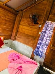 a small room with two beds and a fan at Rooms at Maduka Restaurant in Ilandaiyadi