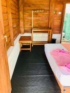 a room with two beds and a wooden wall at Rooms at Maduka Restaurant in Ilandaiyadi