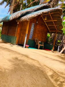 a house on the side of a dirt road at Rooms at Maduka Restaurant in Ilandaiyadi