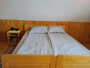 a wooden bed with two pillows on it in a room at Konak kik in Zaovine