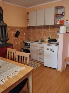 a kitchen with a white refrigerator and a table at Konak kik in Zaovine