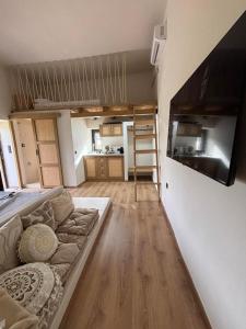 a living room with a couch and a kitchen at Mani Spot Elmare in Okhiá