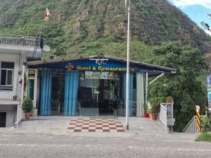 a hotel and restaurant with a mountain in the background at K C Hotel & Restaurant in Rudraprayāg