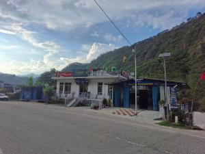 a building on the side of a street with a mountain at K C Hotel & Restaurant in Rudraprayāg