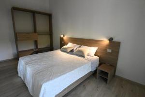 a bedroom with a large bed with a wooden headboard at Corte Nascimben in Marano di Valpolicella +21 photos