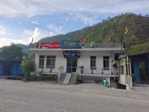 a building on the side of a street with a mountain at K C Hotel & Restaurant in Rudraprayāg