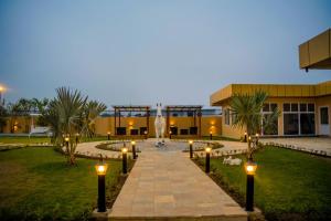 a building with a fountain and lights in front of it at Gautam Hotel Dhanusha in Lālbhitti