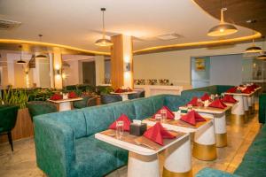 a restaurant with a green couch and tables with red napkins at Gautam Hotel Dhanusha in Lālbhitti