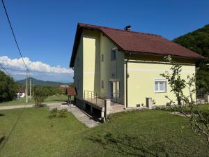 a yellow house with a red roof at Kuća za odmor NIMA in Gospić
