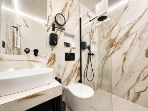 a bathroom with a sink and a toilet and a shower at Hotel Pizzeria Selva in Zernez +23 photos