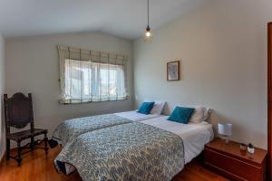 a bedroom with a large bed and a window at Alegria Beach House in Vila do Conde