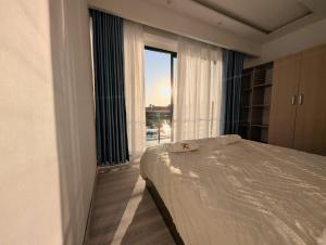 a bedroom with a bed and a large window at Riva guest house in Antananarivo
