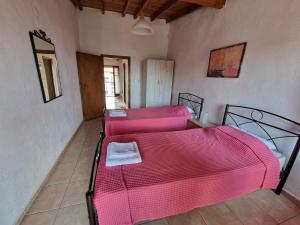 a bedroom with a pink bed and a couch at Cozy apartment with a great view! R in Metamorfosi
