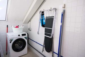 a laundry room with a washing machine and a washer at Alegria Beach House in Vila do Conde