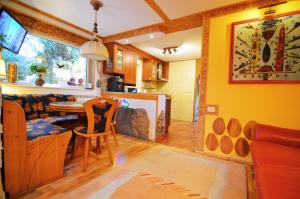 eine Küche und ein Wohnzimmer mit Tisch und Stühlen in der Unterkunft FOREST RETREAT Luxury Villas in Buşteni