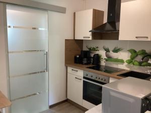 a kitchen with white cabinets and a stove at Apartment far away from Africa in Steinach