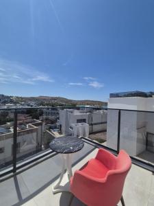 a red chair and a table on a balcony at Lumy Suite Hotel Bodrum Gumbet - Private Pool in Bodrum City