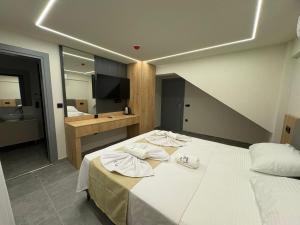 a bedroom with a large white bed with towels on it at Lumy Suite Hotel Bodrum Gumbet - Private Pool in Bodrum City