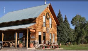 a wooden church with a clock on the front of it at Chama River Bend Lodge in Chama