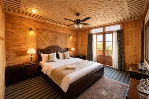 a bedroom with a bed and a ceiling fan at The Heritage Group of Houseboats in Srinagar