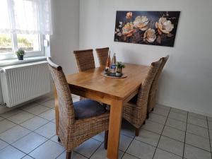 a dining room table with wicker chairs and a wooden table at Ferienhaus Anno 1912 in Klüsserath
