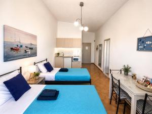 a bedroom with two beds and a table and a kitchen at Gennadi Sun Apartments 500m from the beach in Gennadi