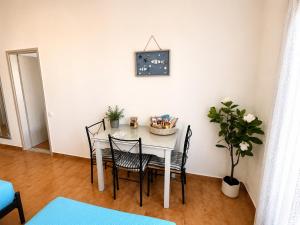 a dining room table with chairs and a clock on the wall at Gennadi Sun Apartments 500m from the beach in Gennadi
