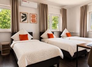 two beds in a room with two windows at BASE stay Erlangen in Erlangen