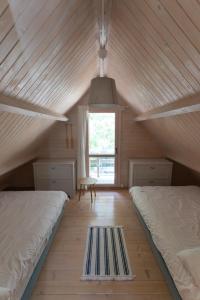 a attic room with two beds and a window at Domki Pod Sosnami in Rowy