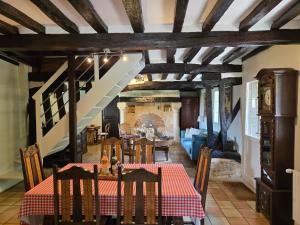 a dining room with a table and a staircase at La Maraiquaise in Marais-Vernier