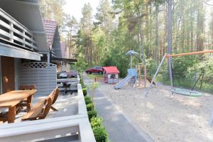 a playground with a picnic table and a swing at Domki Pod Sosnami in Rowy