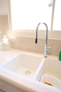 a sink in a kitchen with a window at סוויטת אריאל - סוויטה משפחתית עם מרפסת בבית שאן in Bet Sheʼan +7 photos