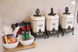 a group of three white containers sitting on a shelf at סוויטת אריאל - סוויטה משפחתית עם מרפסת בבית שאן in Bet Sheʼan