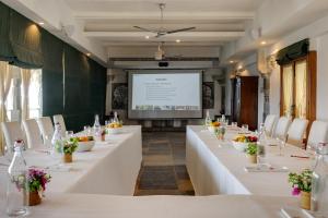 a meeting room with white tables and chairs and a screen at RAAS Devigarh in Udaipur +202 photos