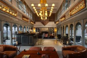 a lobby with chairs and a bar in a building at RAAS Devigarh in Udaipur