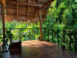 a porch with a wooden deck with plants at Habarana Tree House - Ivory cottage in Habarana