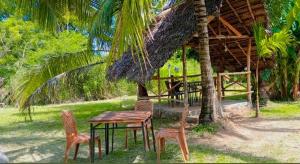 a table and chairs in front of a hut at Grandmila Resort in Anuradhapura
